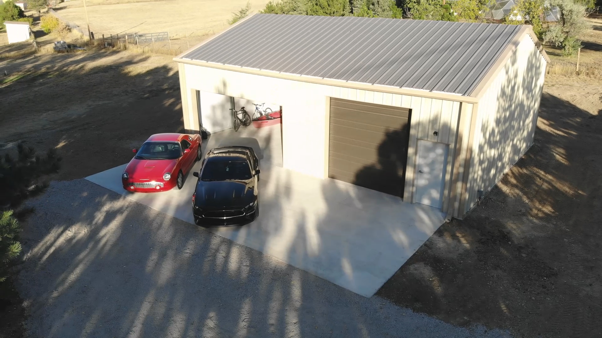 custom car garage and shop by Great Western Buildings in Aurora, Colroado for their customer Randy with a Ford Mustang and Thunderbird parked outside Front