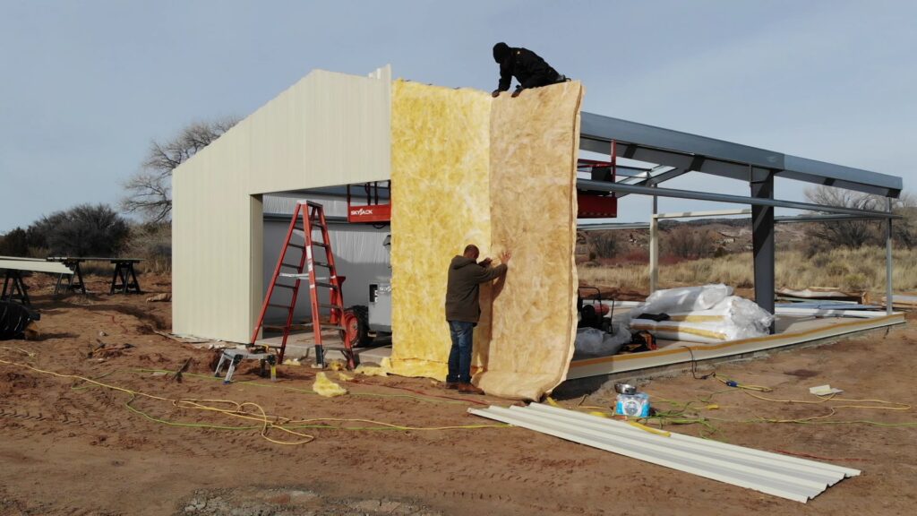 Installing compression fiberglass insulation on a Great Western steel building kit